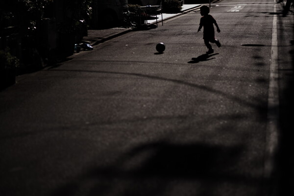 路上でボール遊びをする子供の作例写真